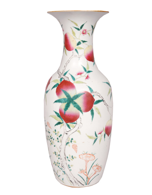 A tall baluster vase with peaches