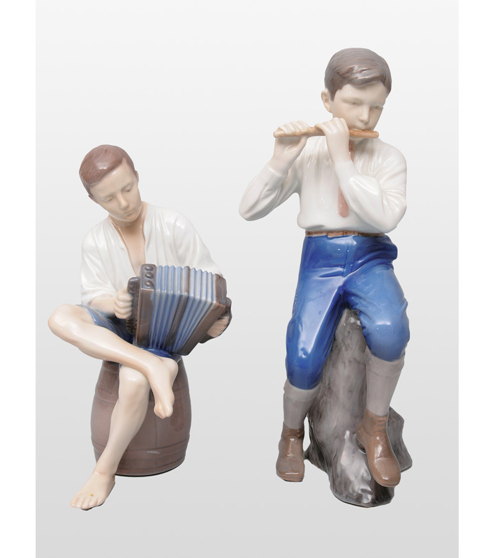 Two figurines "Flute playing boy" and "Accordion playing boy"