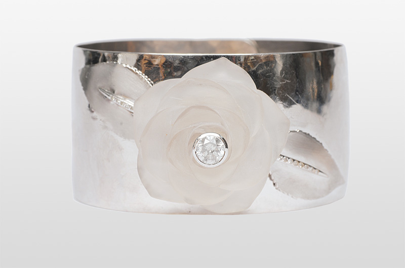 A modern bangle bracelet with diamonds and a rose