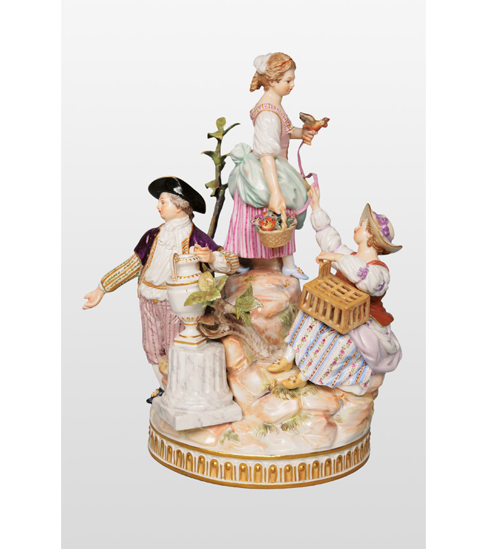 A figurine group "Three gardener"s children with bird"