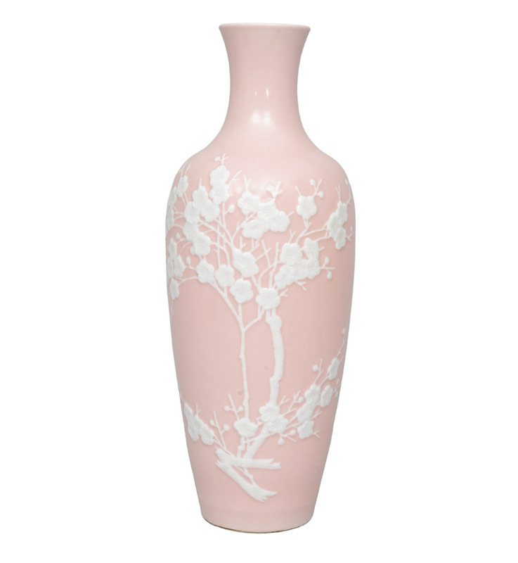 An elegant pink underground vase with blossoming plum branch