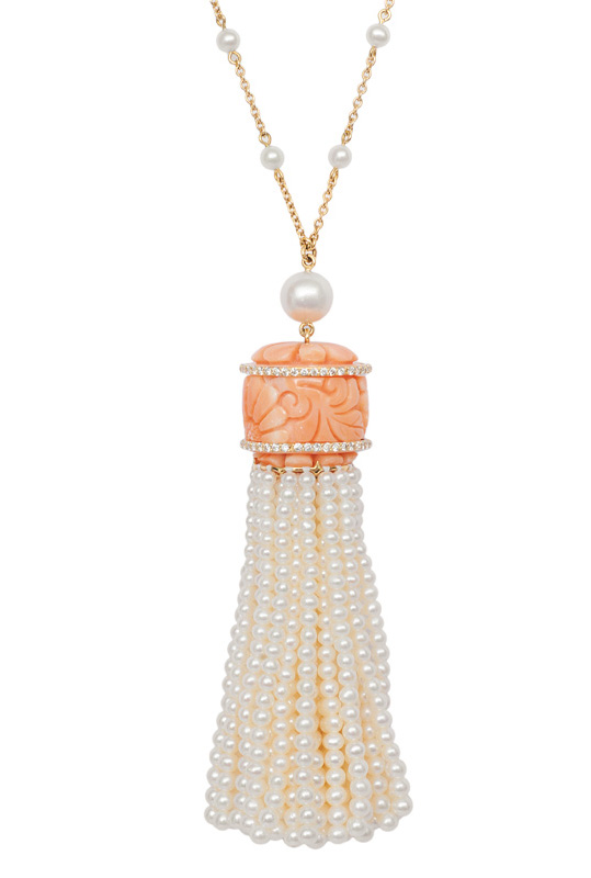 A petite necklace with a coral pearl pendant