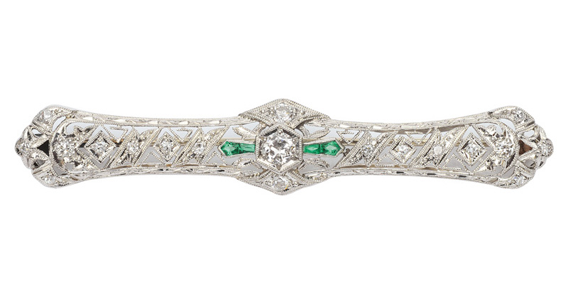 A brooch with diamonds and small emeralds