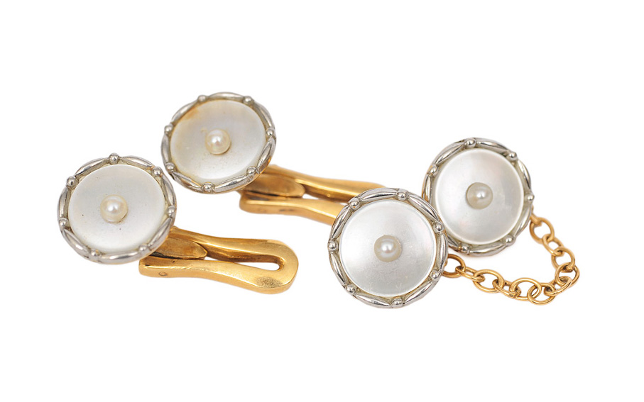 A pair of studs with one dress shirt stud