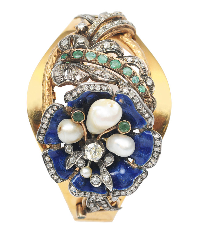 An antique bangle bracelet with diamonds, emeralds and pearls