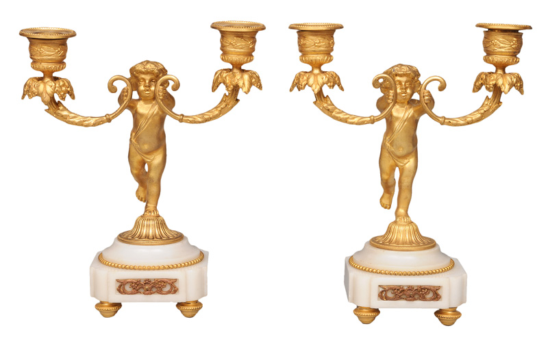 A pair of bronze and onyx candle holders with putto