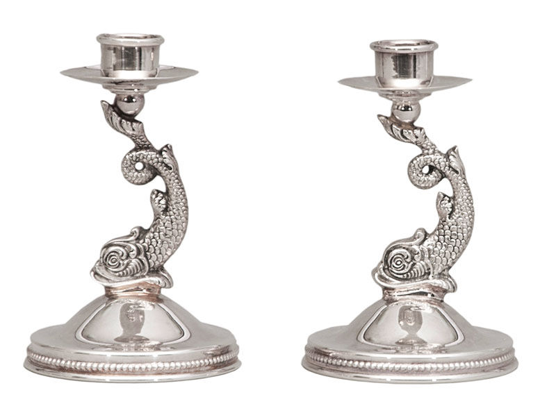 A pair of table candlesticks with dolphin decor