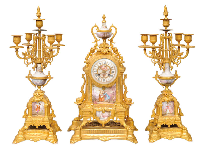 A mantle clock with a pair of candle holders with porcellain application
