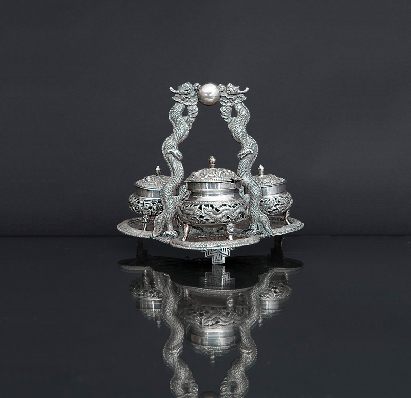 A silver cruet stand with dragon decoration