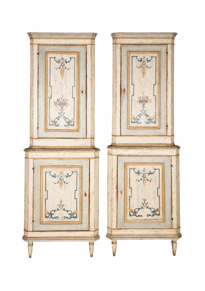 A pair of corner cabinets with painted arabesques