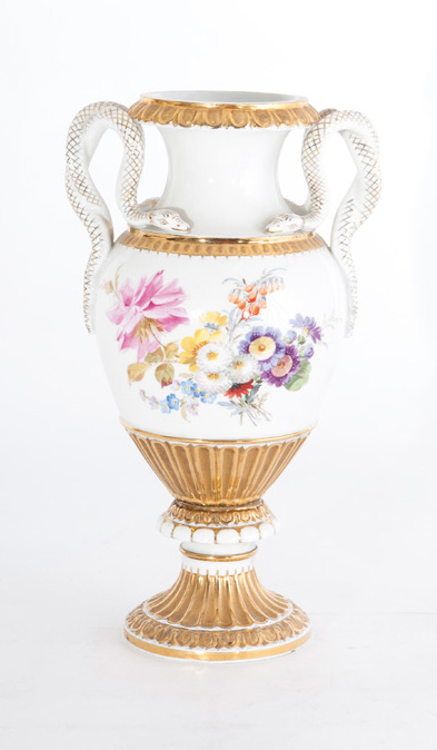 A vase with snake handles and flower bouquets