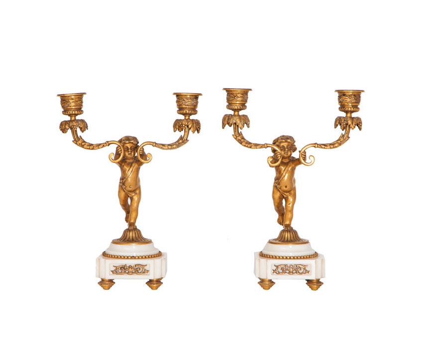 A pair of candlesticks with putti figures