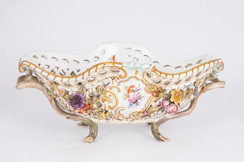 A fruit basket with openworked rim and plastical flowers