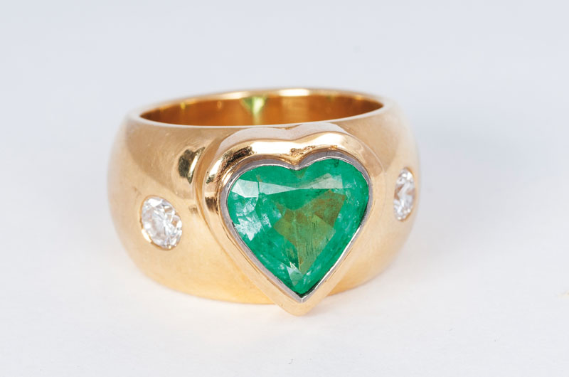 A modern diamond ring with heart shaped emerald