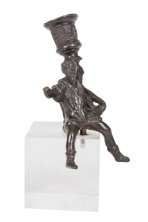 A small bronze 'Candle-holding man'