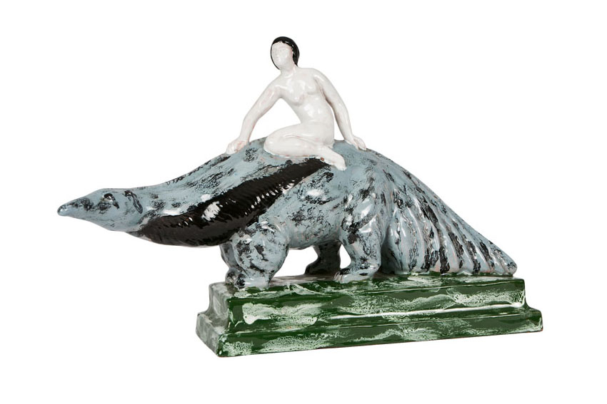 A faience figure 'female nude sitting on a giant anteater'