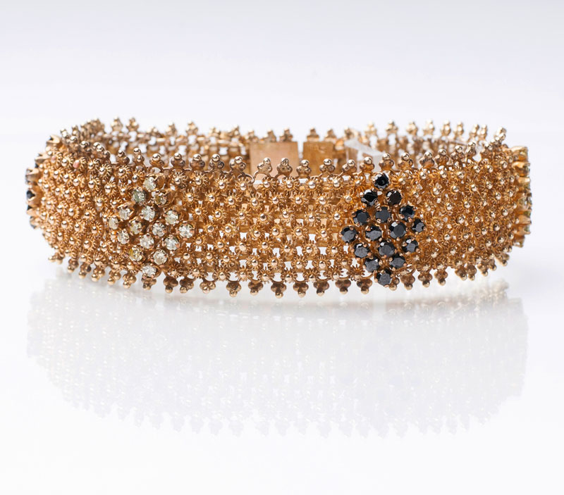A golden bracelet with two coloured diamonds
