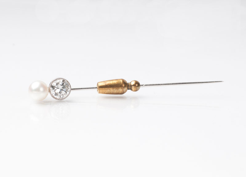 A tie pin with a solitaire and a pearl