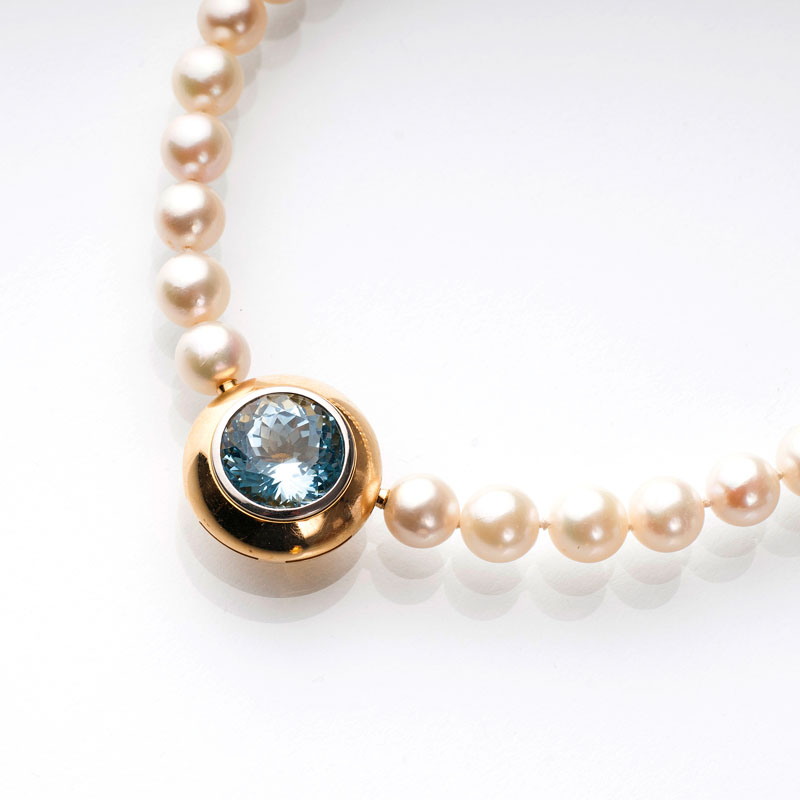 A pearl necklace with one citrine and one aquamarine clasp
