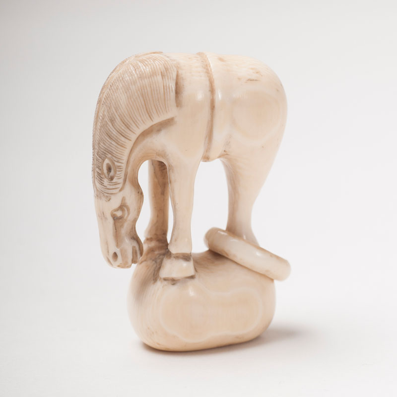 An ivory netsuke 'horse out of the bag'