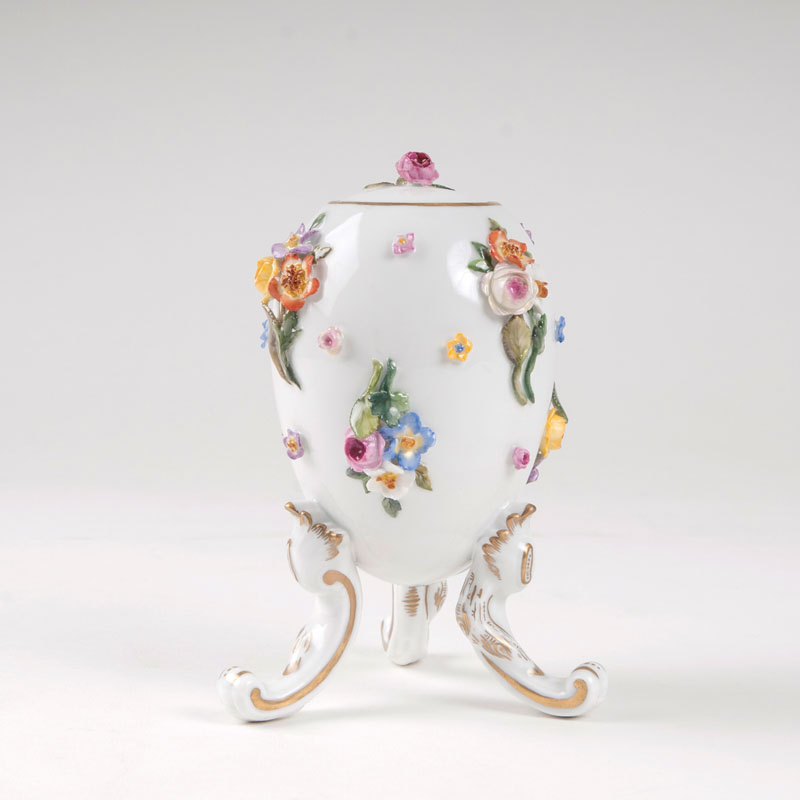 A decorative lidded three-legged vessel