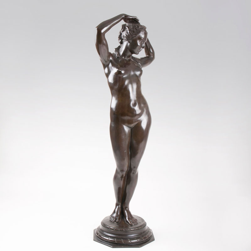 A bronze sculpture 'Female nude with floral wreath'