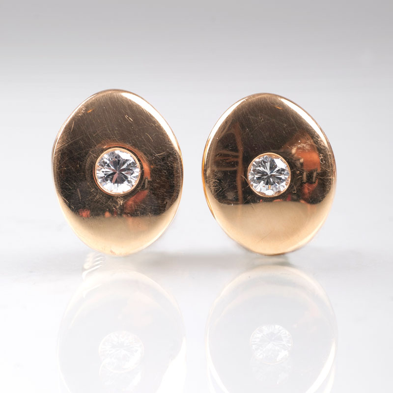 A pair of golden earrings with solitaire diamonds