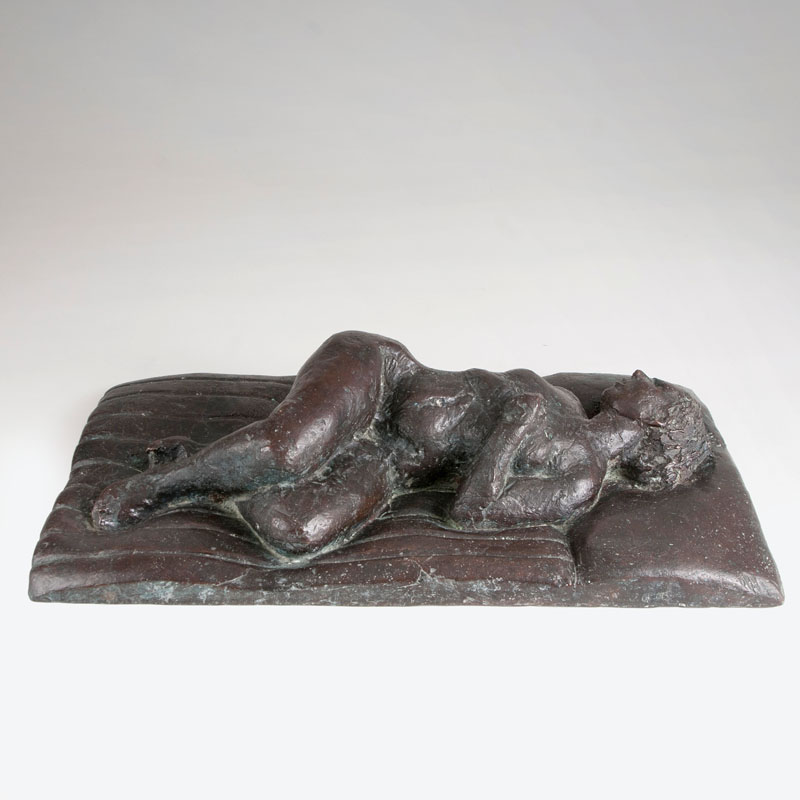 A bronze sculpture 'Reclining female nude on a mattress'