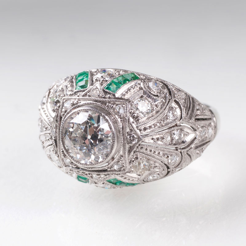 An Art Déco solitaire diamond ring with emeralds