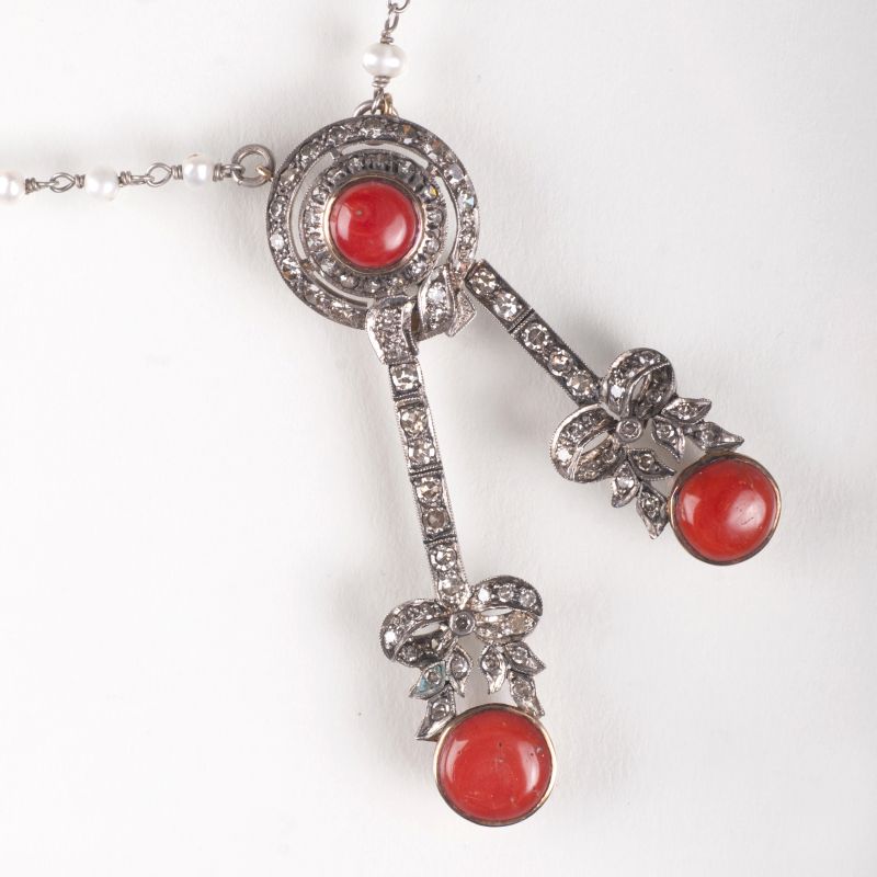 A coral diamond pendant with pearl necklace