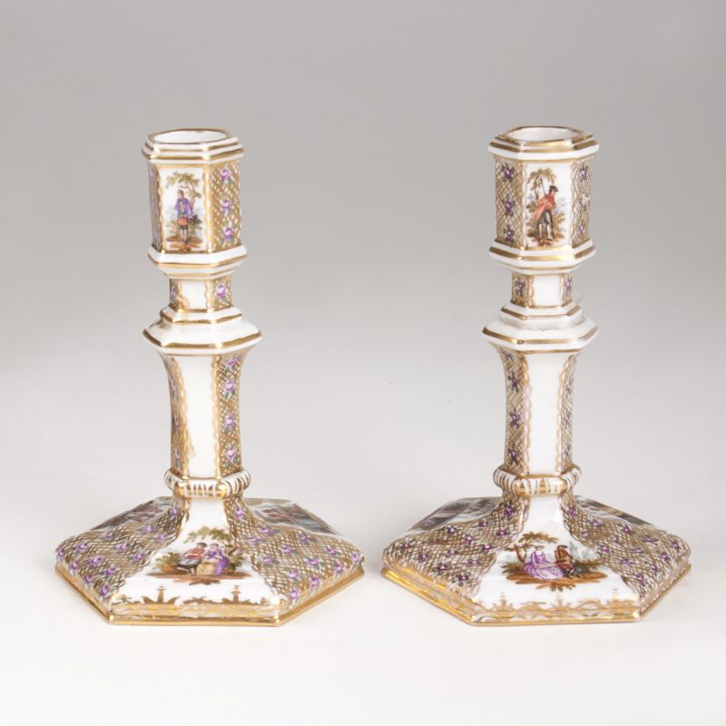 A pair of porcelain candlesticks with Watteau scenes