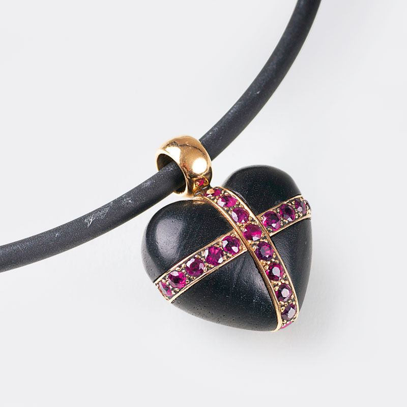 A heart shaped wood pendant with rubies