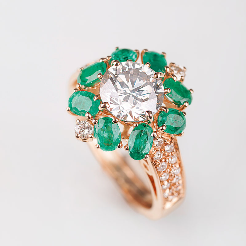 A solitaire diamond ring with emeralds and diamonds