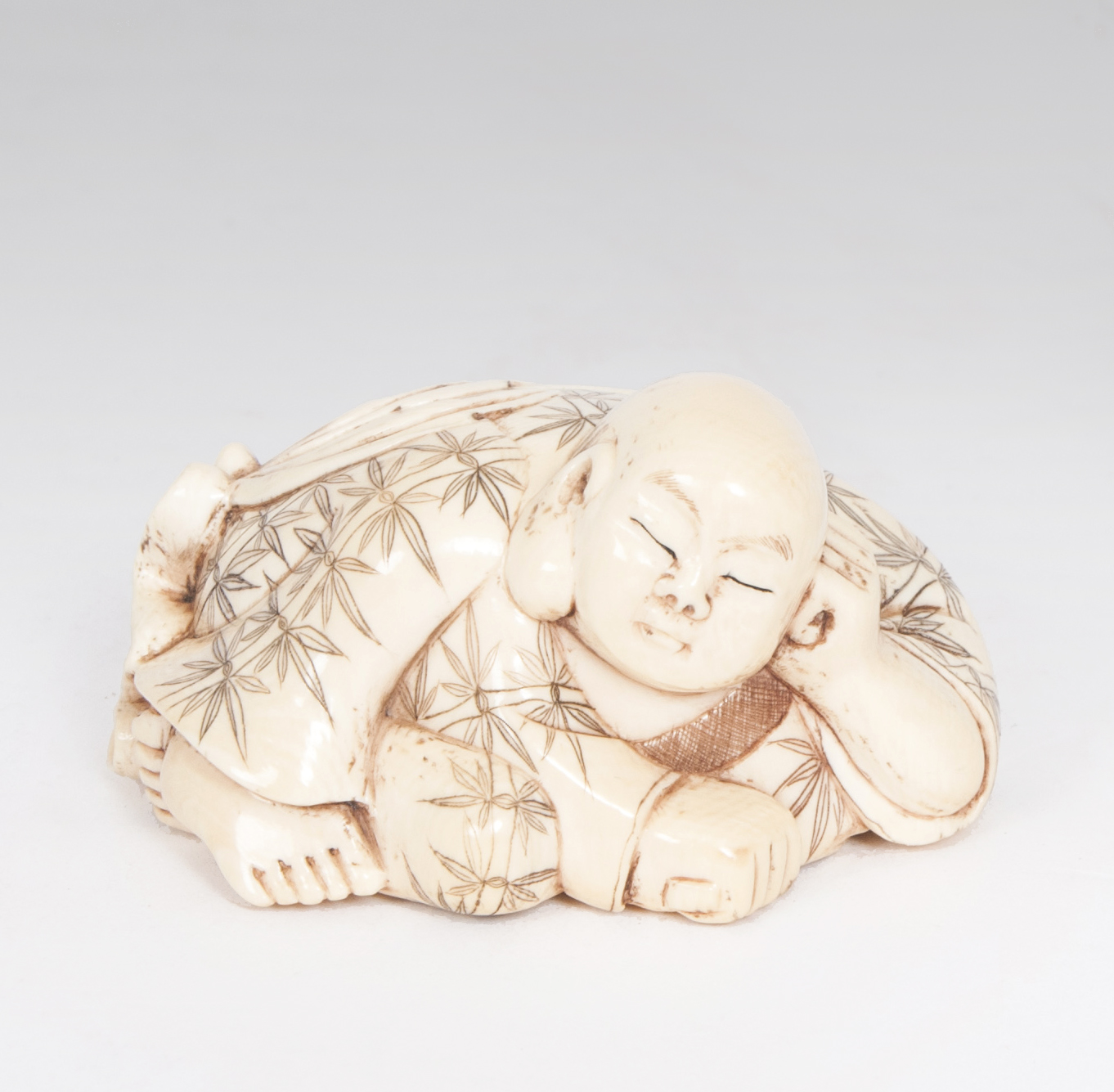 An ivory okimono 'Recumbent budai'