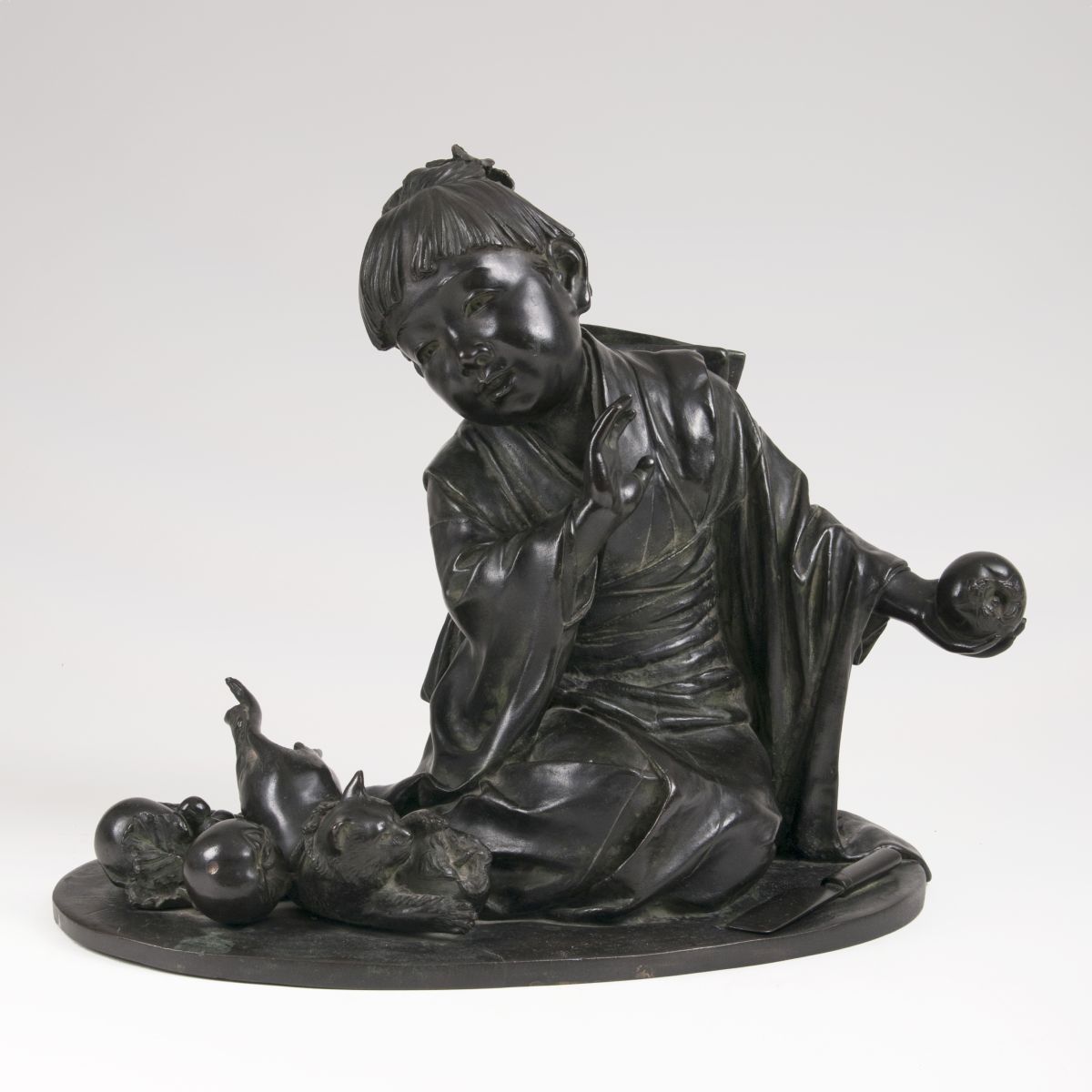 A Japanese bronze sculpture 'Child with playing cat and khaki fruits'
