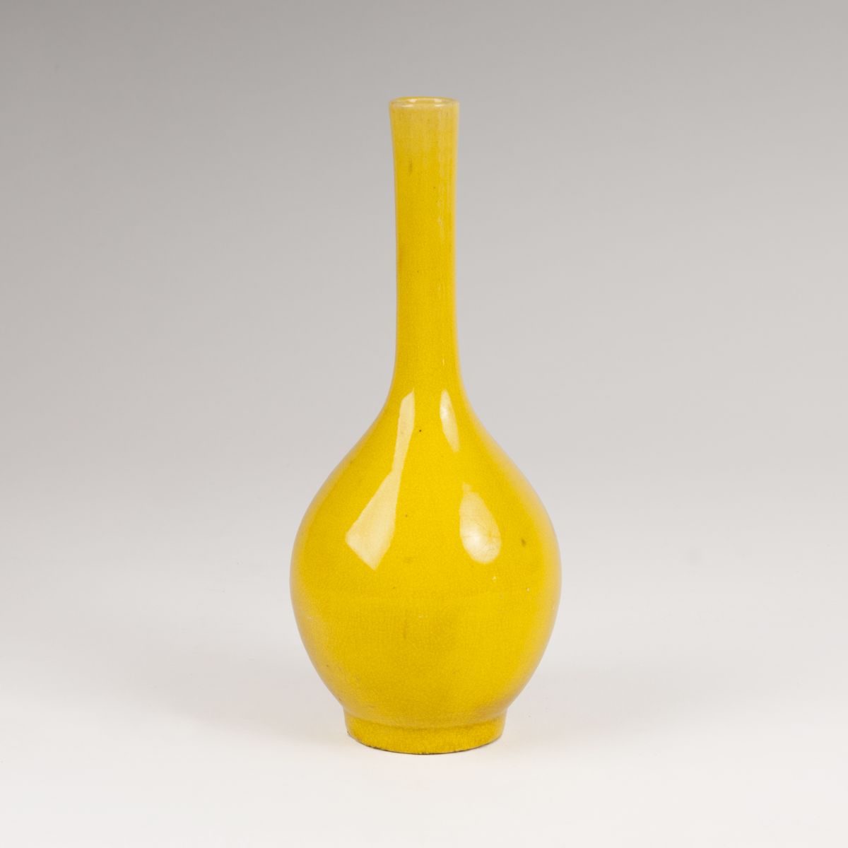 A small porcelain narrow neck vase with lemon-yellow glaze