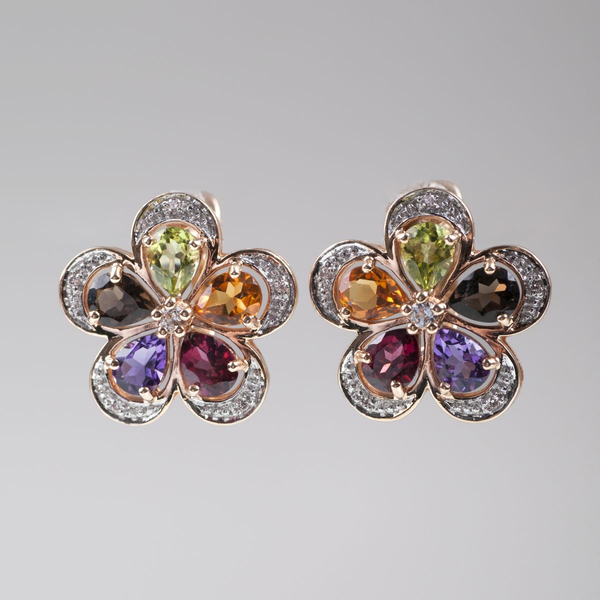 A pair of flowershaped earrings with multicoloured precious gemstones