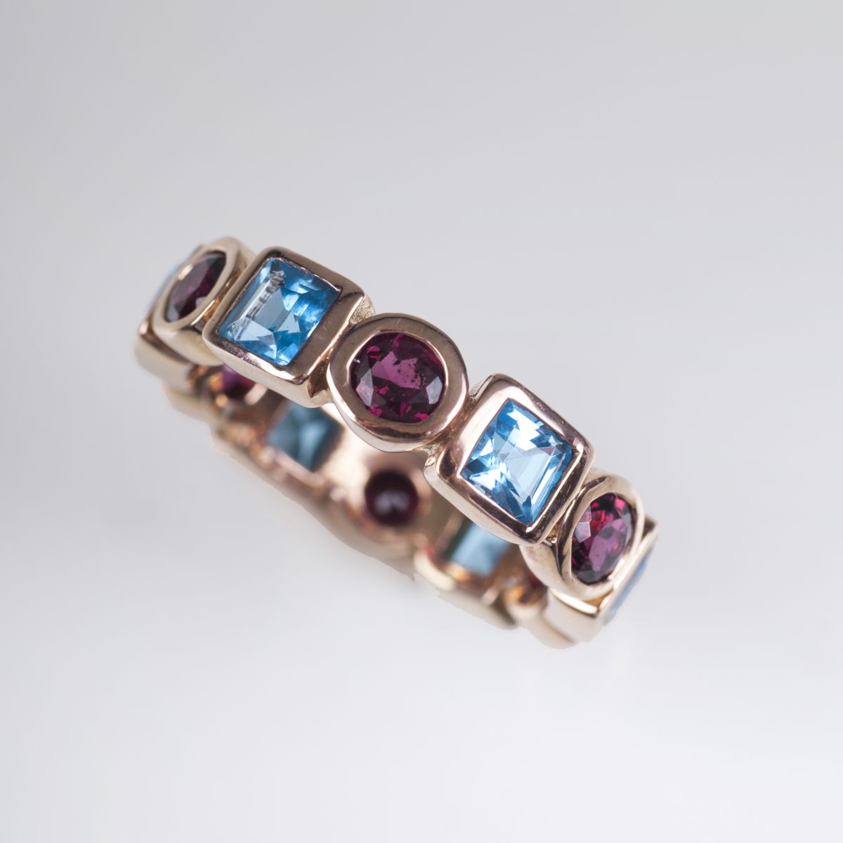 A memory ring with blue topaz and garnet