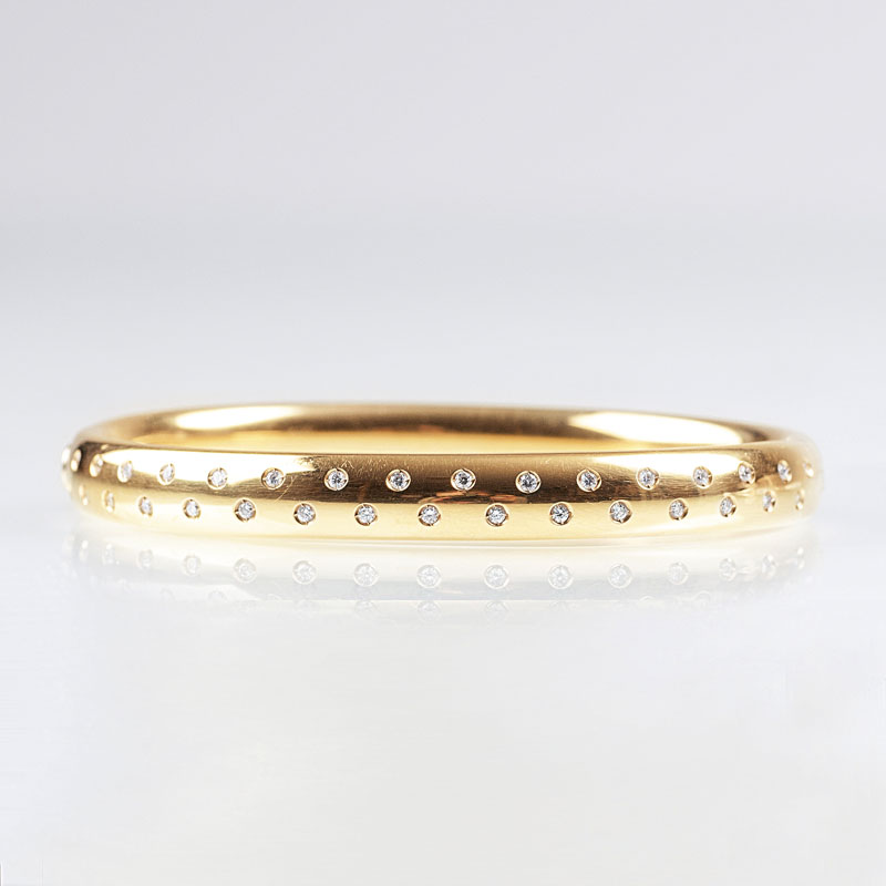 A golden bangle bracelet with diamonds