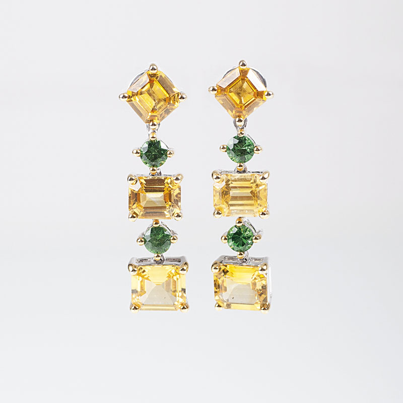 A pair of earrings with yellow sapphires and tsavorits
