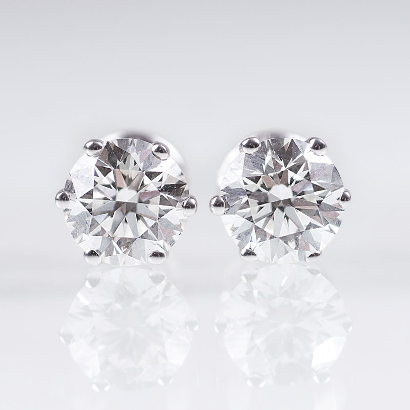 A pair of fine solitaire diamond earrings