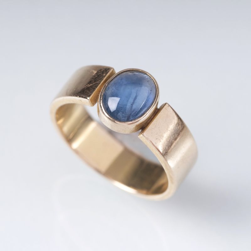A gold ring with a sapphire cabochon