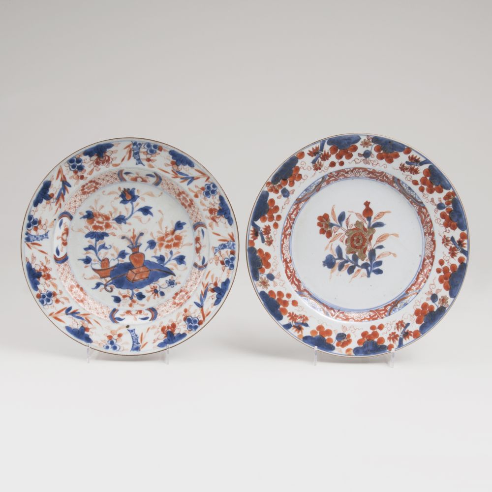 Zwei Imari-Teller mit Blumen-Früchte-Dekor und Artemisia-Blatt in Vase