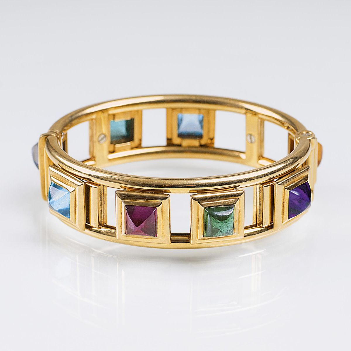 A Gold Bangle Bracelet with Coloured Stones