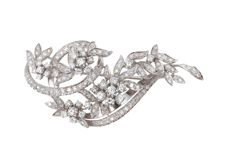 A flower shaped brooch with diamonds