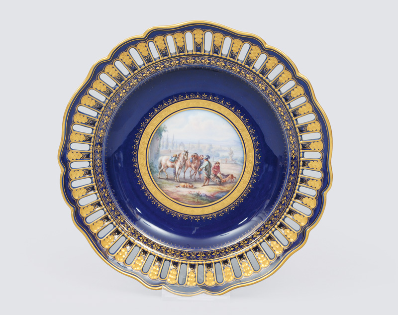 An openwork plate with cobalt blue ground and a fine painted hunt scene