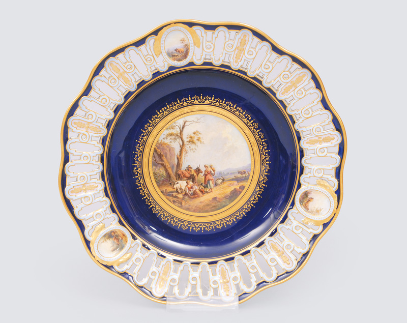 An openwork plate with cobalt blue ground and a fine painted herdmen scene