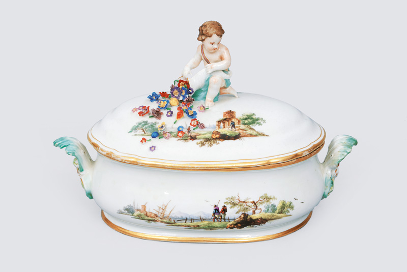 A small tureen with fine painted landscapes and putto crest