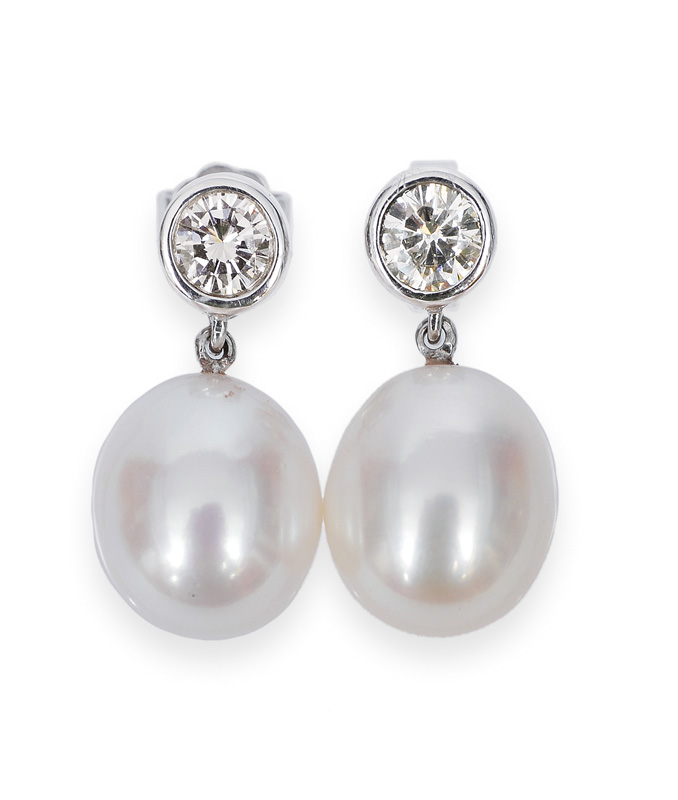 A pair of pearl single stone diamond earrings