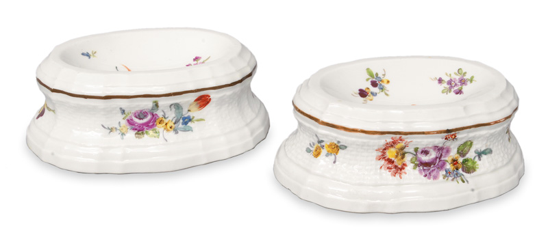 A pair of salt cellars with flower pattern and brown rim line